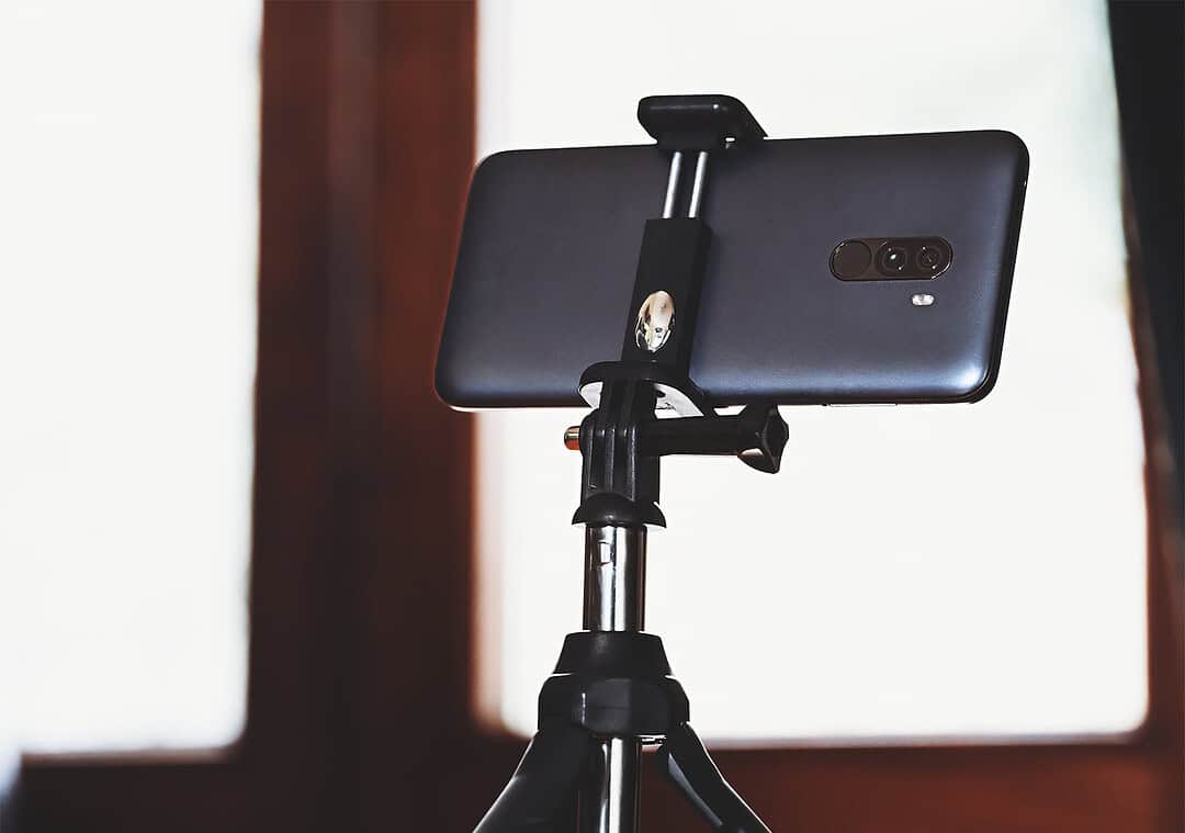 Smartphone montato su mini-treppiede pronto a scattare: esempio di setup semplice per foto Tinder ben composte.